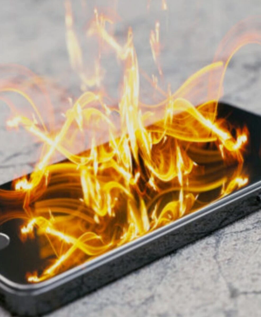 Telefono cellulare in carica con batteria esplosa e fiamme